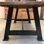 Close-up teaktafel met metalen poot