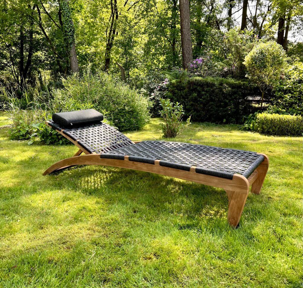 Lounger met zwarte wicker. Het frame is gemaakt van teakhout