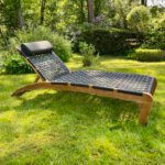 Lounger met donkere wicker. het frame is gemaakt van teakhout