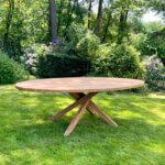 Ovale tuintafel met een kruispoot. De tafel is gemaakt van massief teakhout