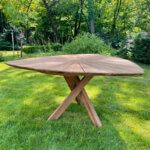 Tuintafel gemaakt van teakhout met een kruispoot en driehoekig blad