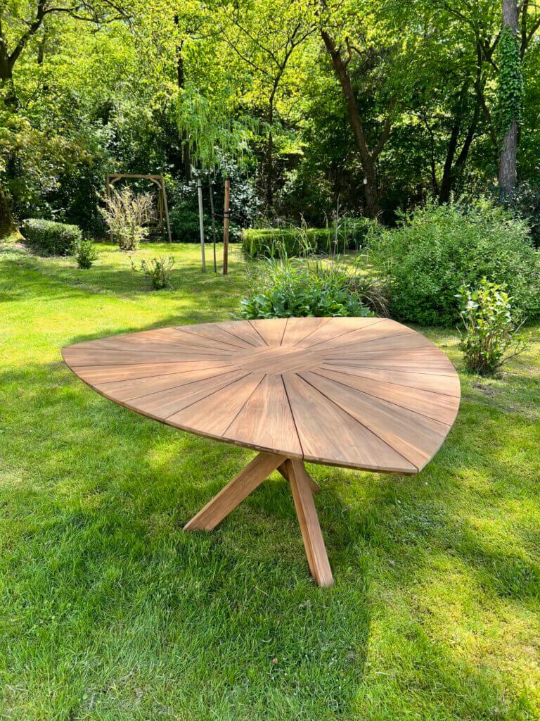 Tuintafel gemaakt van massief teakhout, de tafel heeft een driehoekig blad met een houten kruis poot.