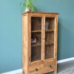 kleine vitrine kast met twee laden en twee deuren gemaakt van teakhout